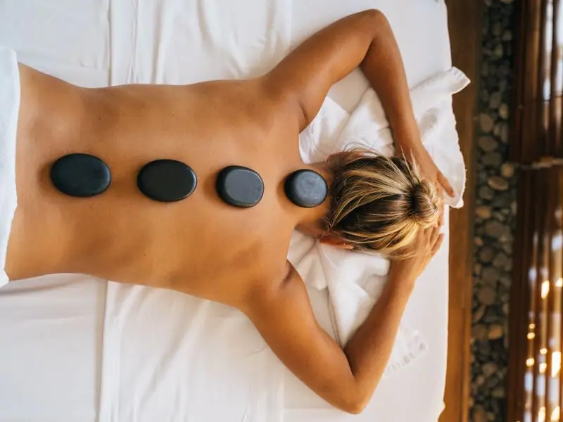 A spa treatment with warm stones arranged on the back